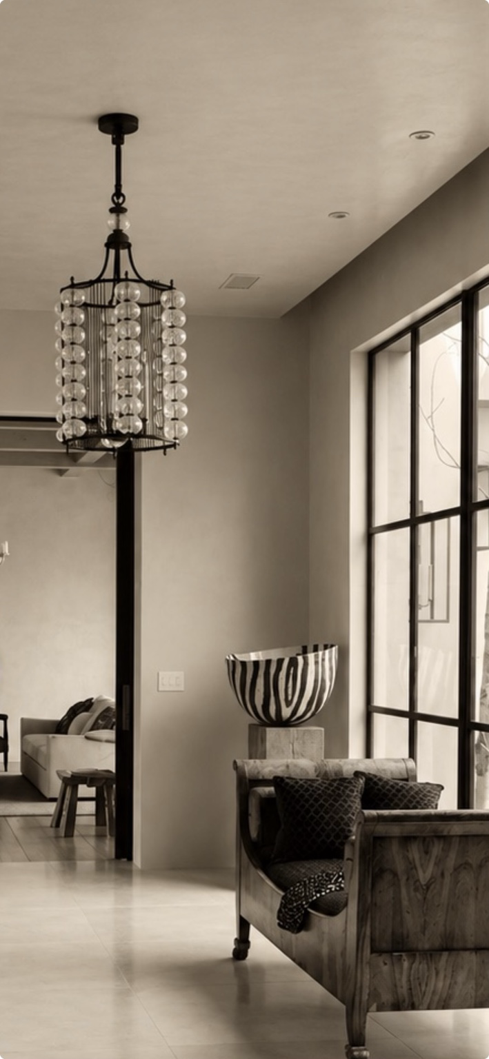Bona Terra interior with hand-finished plaster walls, microcement flooring, blackened steel windows, sculptural lighting and collected furnishings